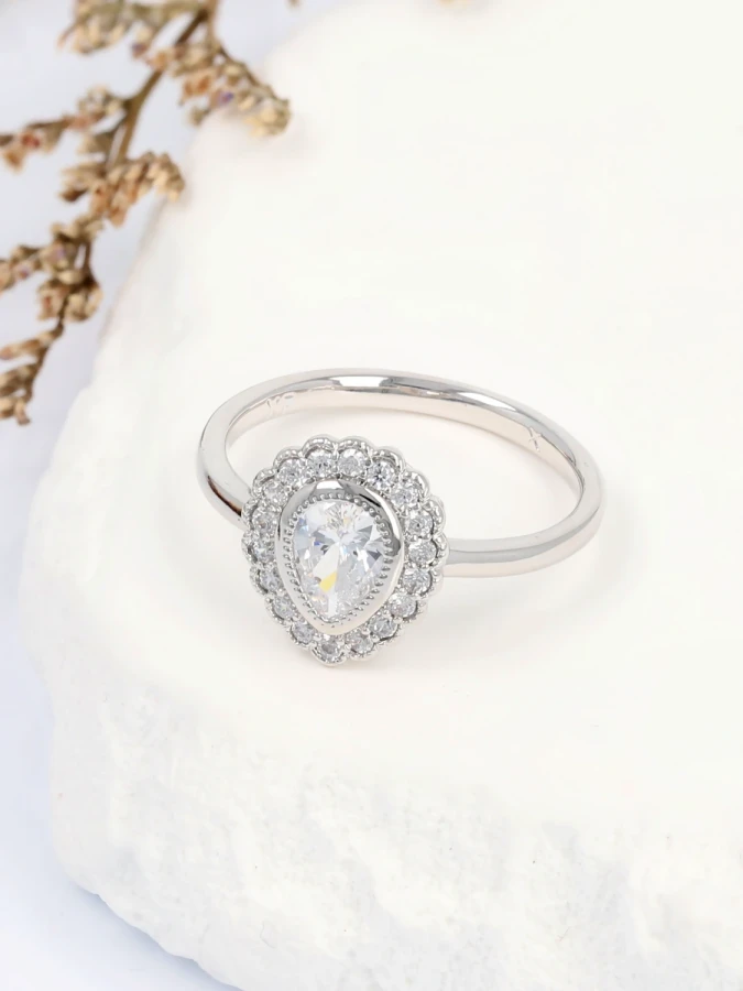 Pierścionek świetlisty medalion z centralną cyrkonią otuloną aureolą drobnych kamieni